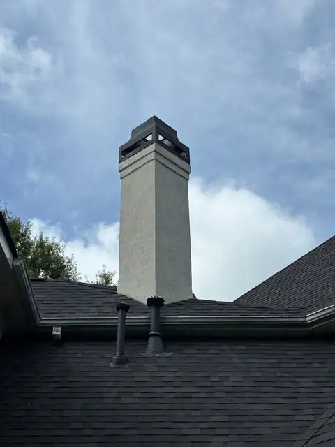 Rebuilt stucco chimney above the roofline