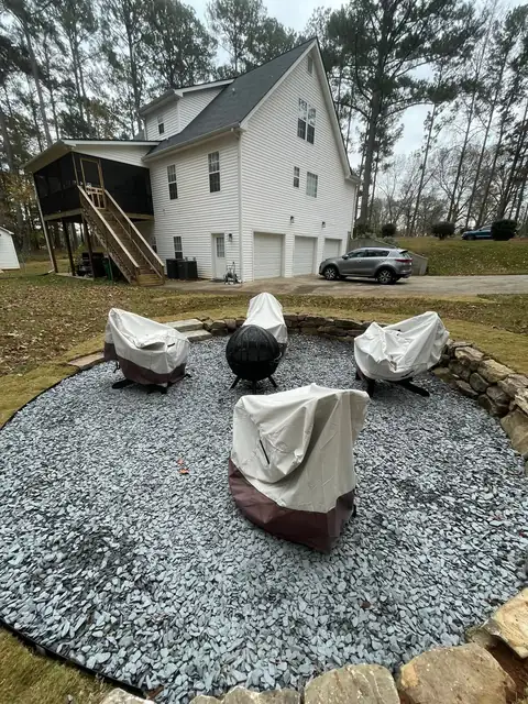 Gravel fire pit circle with a stone border and seating