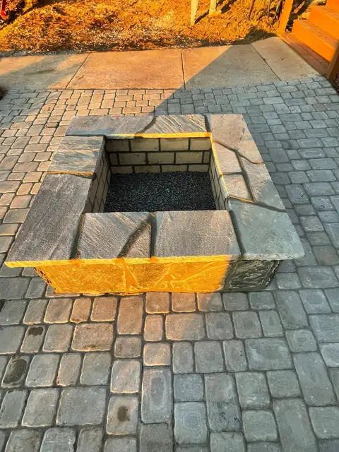 Square fire pit set into a paver patio