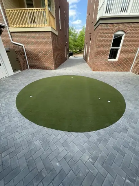 Round turf lawn set into the herringbone pavers