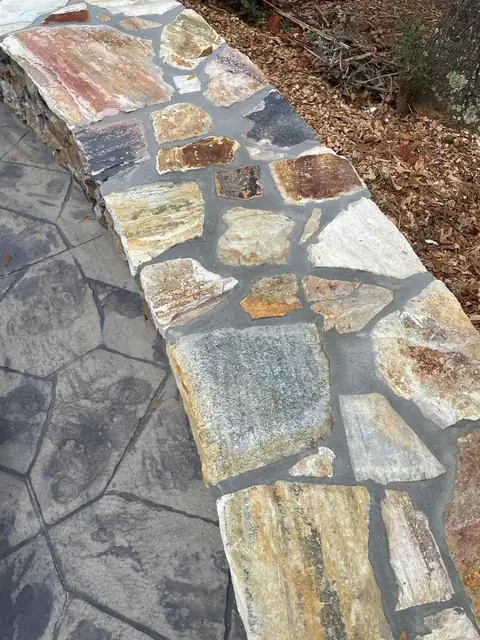Close-up of the fieldstone wall cap against the stamped concrete