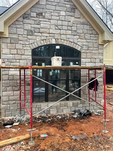 Stone veneer going up around the arched window