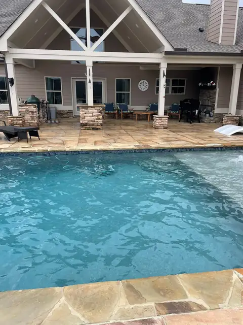 Flagstone pool coping and patio behind a lake house