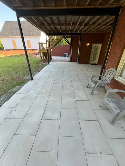 Large-format tile patio under a raised deck